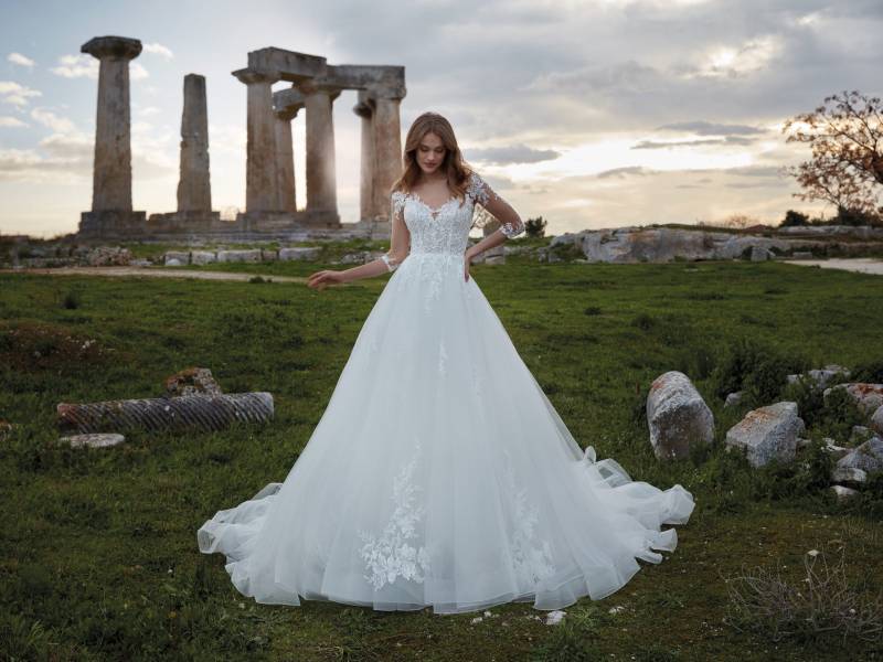  robe  de styliste se distingue par ses manches longues élégantes et son corsage en dentelle fine, offrant un style chic 